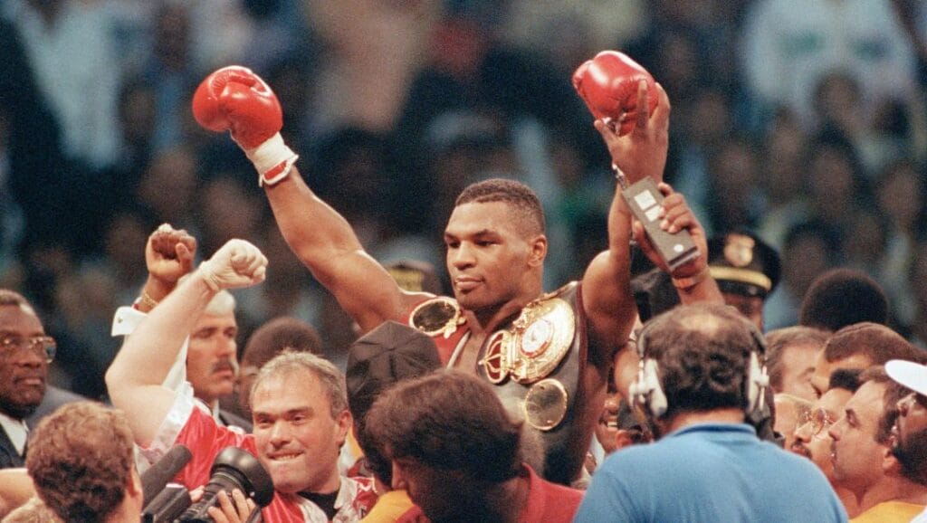 Heavyweight champion of the World Mike Tyson is lifted by the crowd upon winning his bout with challenger Carl "The Truth" Williams.