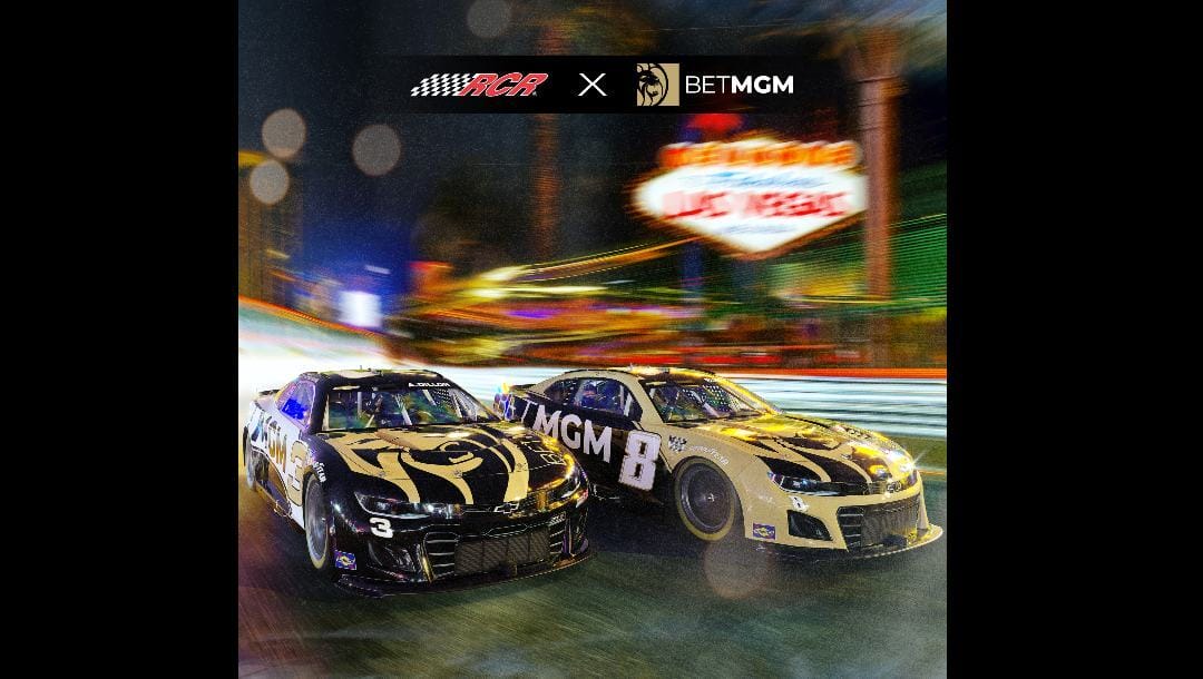 Two racing cars with the "Welcome to Las Vegas" sign in the background