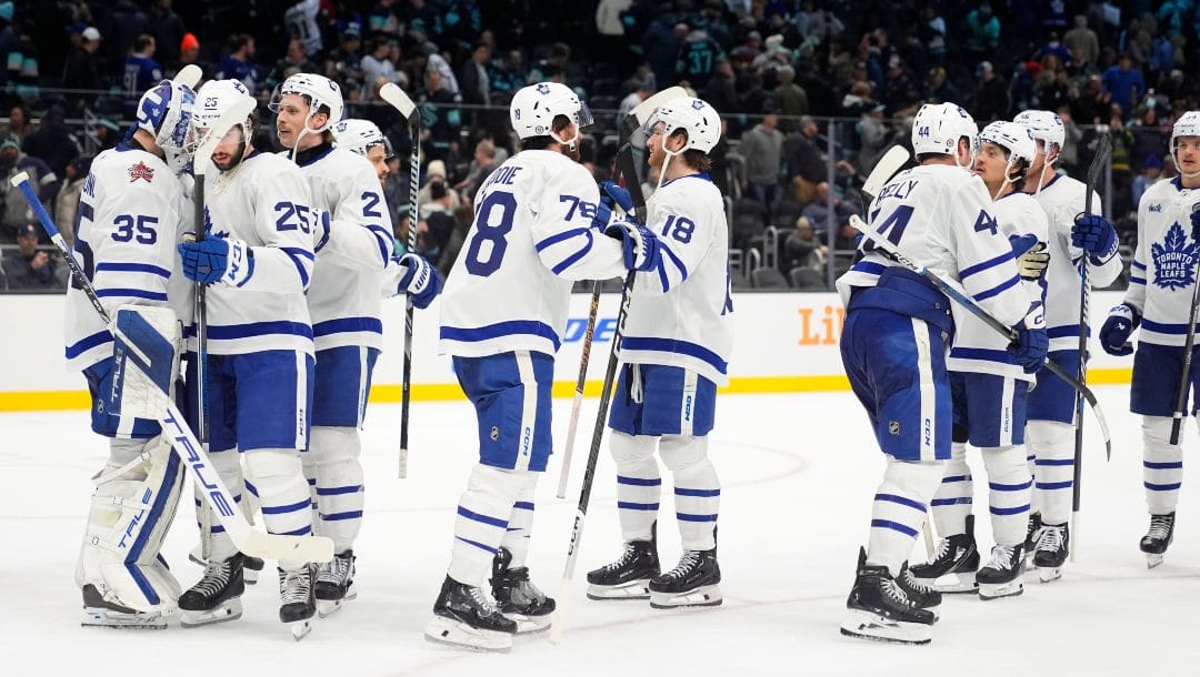 Toronto Maple Leafs, including goaltender Ilya Samsonov (35), celebrate after a win over the Seattle Kraken after an NHL hockey game Sunday, Jan. 21, 2024, in Seattle.