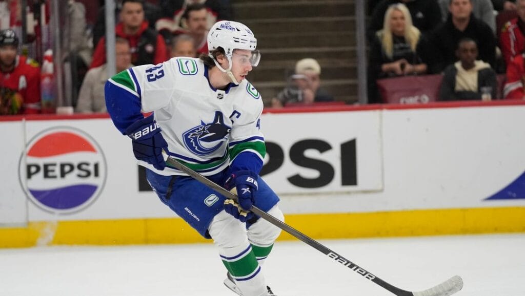 Vancouver Canucks defenseman Quinn Hughes handles the puck during the first period of a hockey game against the Chicago Blackhawks, Tuesday, Feb. 13, 2024, in Chicago.