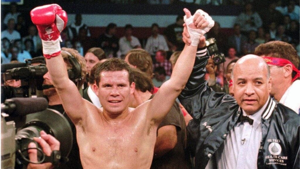 WBC junior welterweight champion Julio Cesar Chavez, left, celebrates his victory over Scott Walker as referee Joe Cortez.