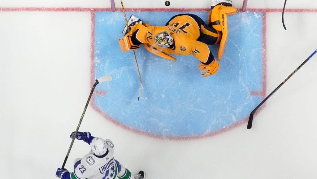 Vancouver Canucks center Elias Lindholm (23) scores a goal past Nashville Predators goaltender Juuse Saros (74) in overtime during Game 4 of an NHL hockey Stanley Cup first-round playoff series Sunday, April 28, 2024, in Nashville, Tenn. The Canucks won 4-3.