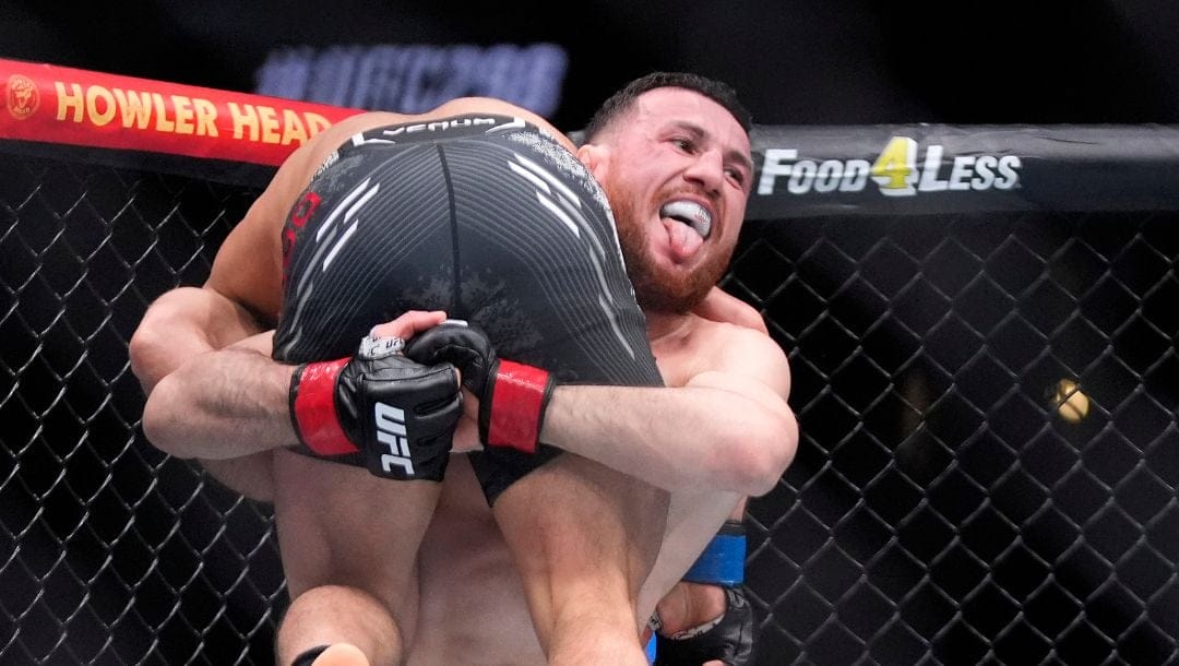 Merab Dvalishvili, right, picks up Henry Cejudo during their bantamweight bout at the UFC 298 mixed martial arts event.