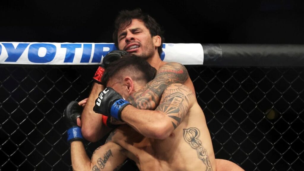 Alexandre Pantoja, top, works Alex Perez into a standing submission in a mixed martial arts bout at UFC 277.