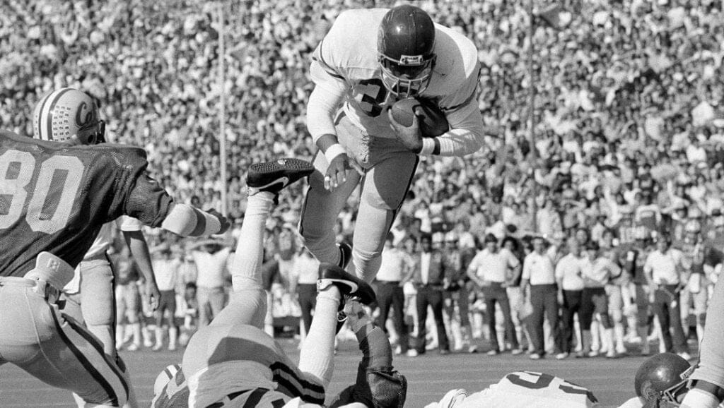 Tailback Marcus Allen (33) of the USC Trojans somersaults into the end zone from the one yard line in first quarter scoring action against the University of California at Berkeley in Berkeley, Calif., Nov. 7, 1981. At left is Berkeley's linebacker Ron Rivera.