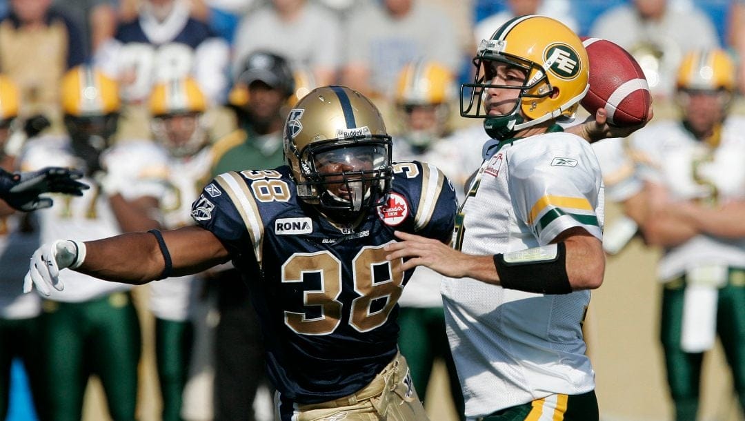 Edmonton Eskimos' Ricky Ray (15) throws under pressure from Winnipeg Blue Bombers' Marcellus Bowman (38) in first half CFL action in Winnipeg, Saturday, July 24, 2010.