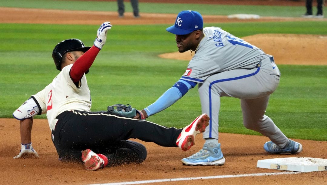 Texas Rangers' Marcus Semien, left, is tagged out by Kansas City Royals third baseman Maikel Garcia, right.