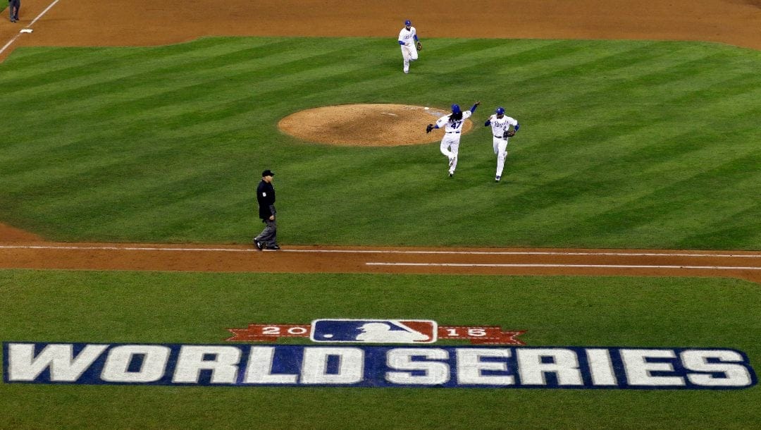 Kansas City Royals starting pitcher Johnny Cueto, left, and shortstop Alcides Escobar celebrates the end of the top of the eighth inning of Game 2 of the Major League Baseball World Series against the New York Mets Wednesday, Oct. 28, 2015, in Kansas City, Mo