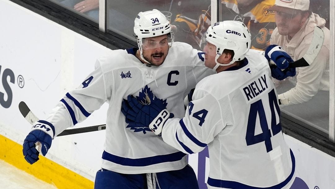Toronto Maple Leafs' Morgan Rielly (44) celebrates his goal with Auston Matthews (34) during the second period of an NHL hockey game against the Boston Bruins, Saturday, Oct. 26, 2024, in Boston.