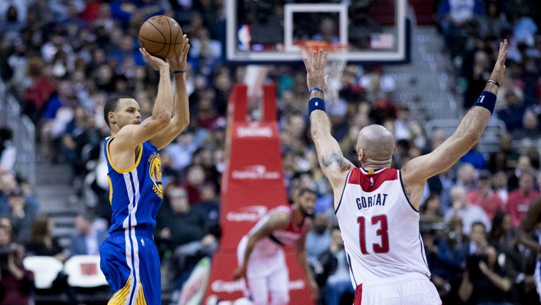 Stephen Curry with the Golden State Warriors shoots in front of Marcin Gortat during a game against the Washington Wizards on February 28, 2017.