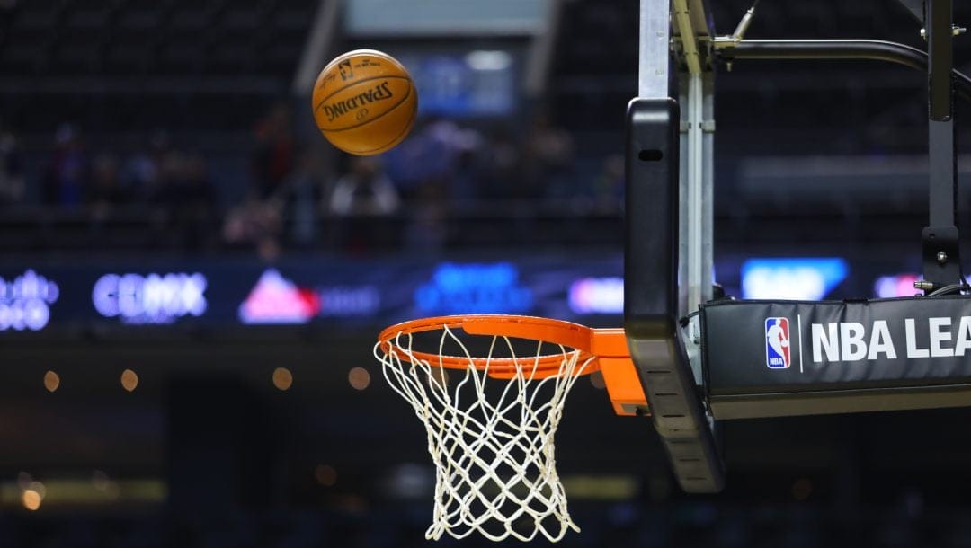 A photo of an NBA basketball going through a hoop.