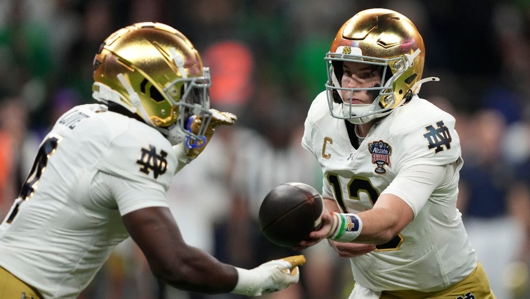 Notre Dame quarterback Riley Leonard hands the ball off to running back Jeremiyah Love, left, during the first half against Georgia in the quarterfinals of a College Football Playoff, Thursday, Jan. 2, 2025, in New Orleans.