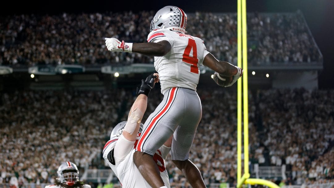 Ohio State wide receiver Jeremiah Smith (4) and offensive lineman Seth McLaughlin celebrate Smith's touchdown during the first half of an NCAA college football game, Saturday, Sept. 28, 2024, in East Lansing, Mich.