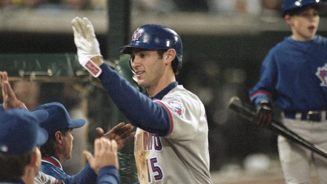 Toronto Blue Jay Shawn Green prepares to high-five teammates in the dugout at Edison International Field in Anaheim, California on May 6, 1998, after hitting a two-run homerun in the seventh inning against the Anaheim Angels to tie the game at 5-5. The Blue Jays won 6-5.