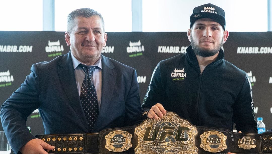 UFC lightweight champion Khabib Nurmagomedov, right, and his father Abdulmanap Nurmagomedov pose with the trophy belt.