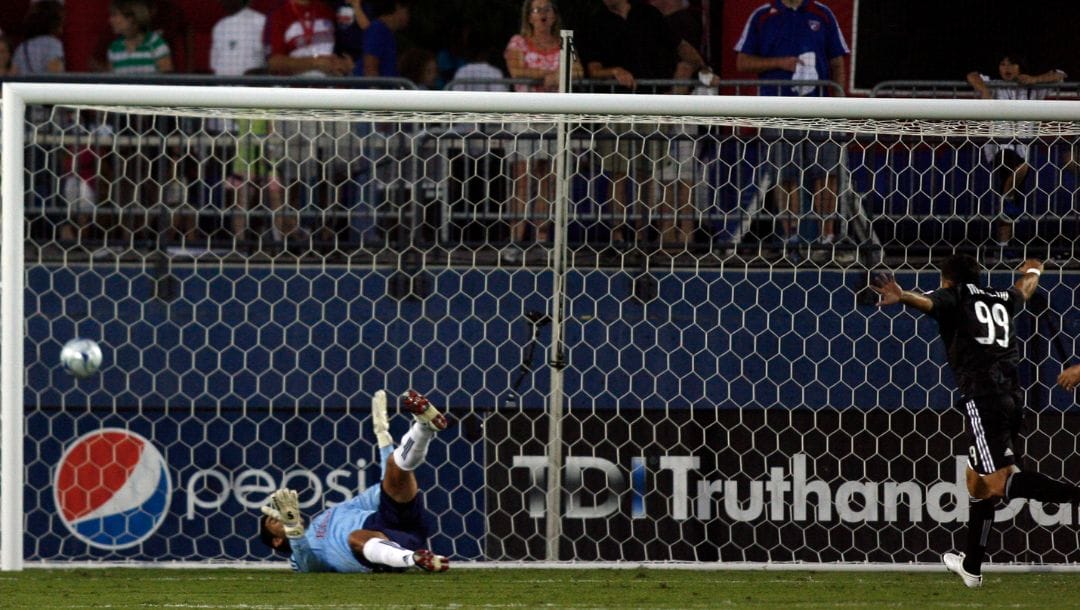 Bolivian forward Jaime Moreno of DC United celebrates after teammate Marc Burch scored a goal in front of FC Dallas' Argentine.