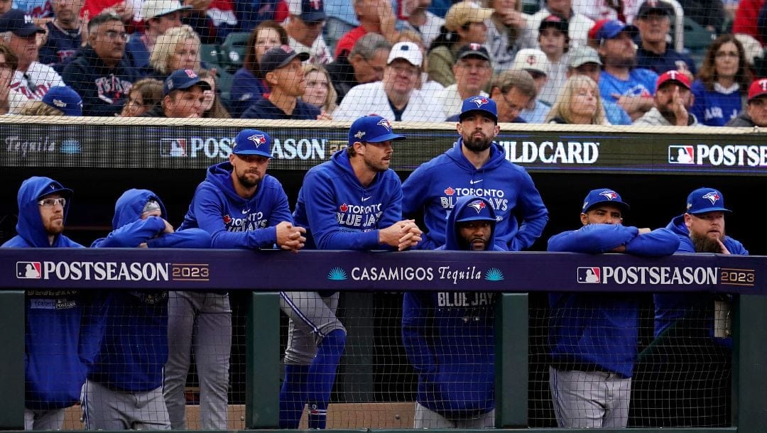 Toronto Blue Jays players watch from the dugout during the eighth inning of Game 2 of an AL wild-card baseball playoff series.