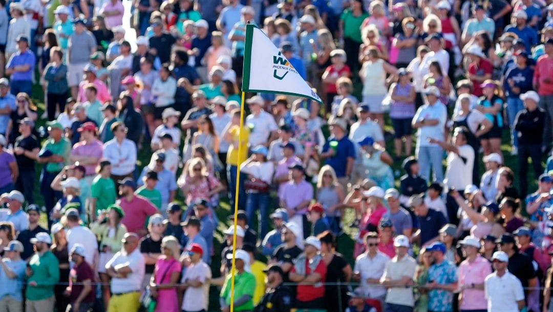 The flag stick and golf fans on the 18th hole during the Phoenix Open golf tournament, Sunday, Feb. 12, 2023, in Scottsdale, Ariz.