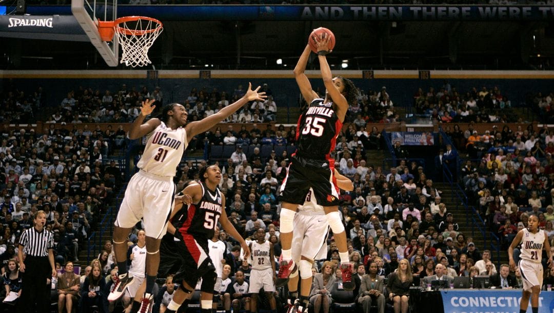 Louisville's Angel McCoughtry grabs a rebound as Connecticut's Tina Charles reaches in to block in the second half.