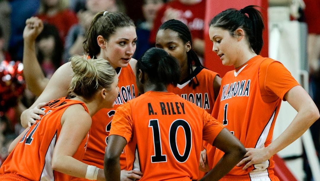 Oklahoma State players, including Ally Clardy (11), Andrea Riley (10) and Tegan Cunningham (1), huddle in the second half.