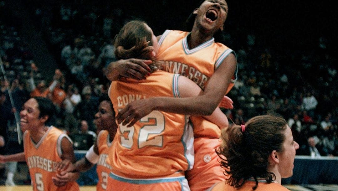 Tennessee's Chamique Holdsclaw (top) leaps high into the arms of teammate Abby Conklin (52) as they upset top ranked Connecticut.