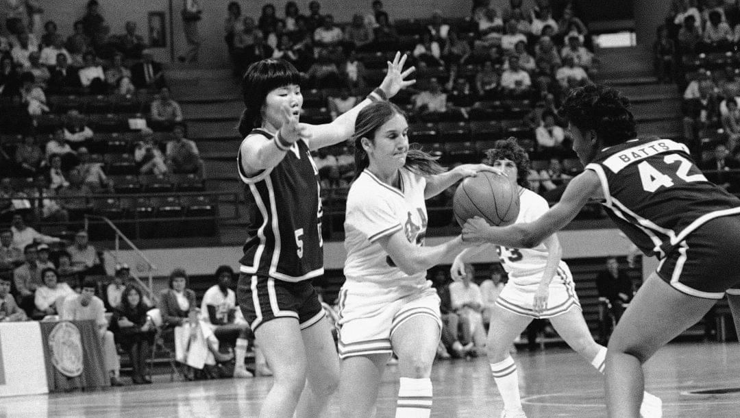 University of Texas guard Kamie Ethridge is surrounded by Northeast Louisiana University's Eun Jung Lee (5) and Angela Bates (42) during the Mid-West Regional Women's Basketball Tournament, Friday, March 24, 1984 in Ruston, La. Texas won the game 99-91.
