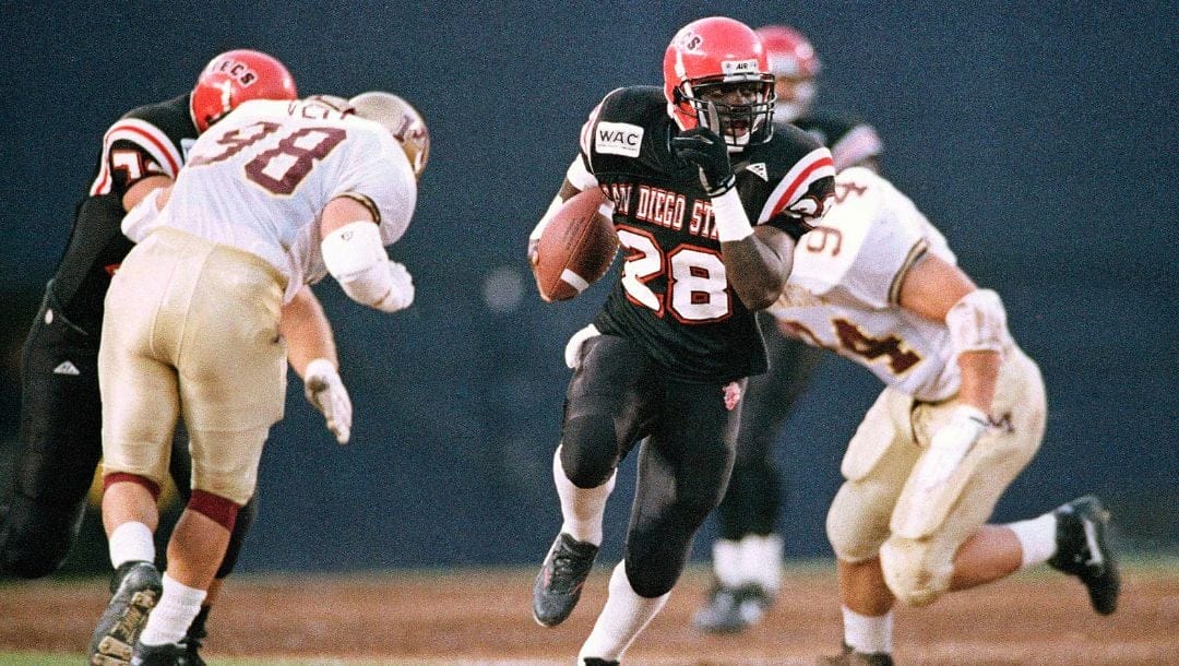 FILE - In this Sept. 25, 1993, file photo, San Diego State running back Marshall Faulk breaks away from two Minnesota defenders.