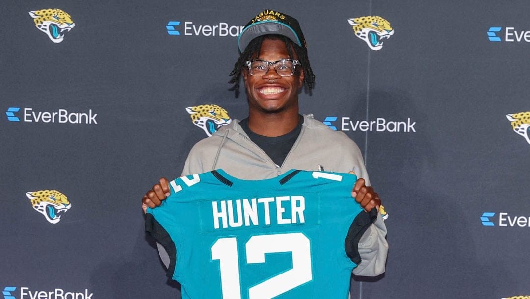 Two-way player Travis Hunter, the Jacksonville Jaguars first round draft pick, second overall, pose with a jersey during an NFL football press conference, Friday, April 25, 2025, in Jacksonville, Fla.