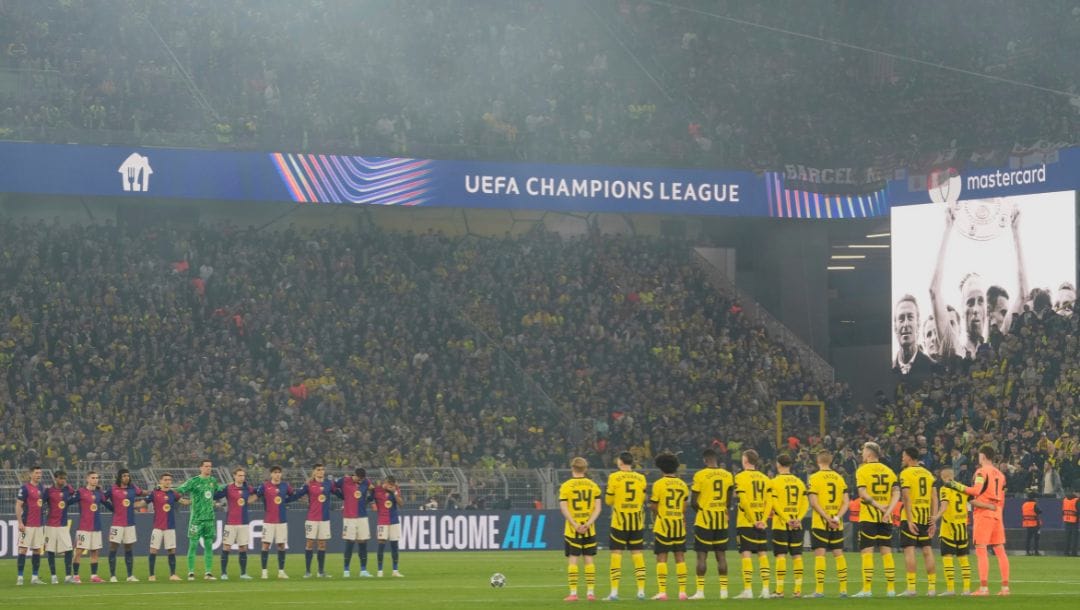 Players attend a silent minute in honor of Borussia Dortmund icon Wilhelm Burgsmuller prior to the Champions League quarterfinals.