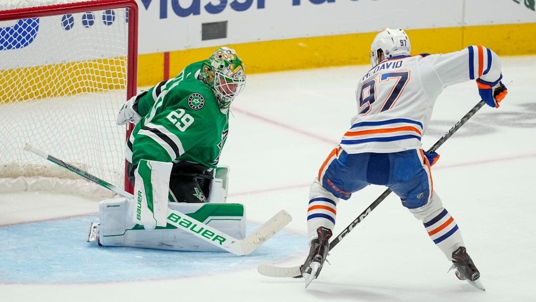 Edmonton Oilers center Connor McDavid (97) prepares to shoot against Dallas Stars goaltender Jake Oettinger (29) during overtime in Game 1 of the NHL hockey Western Conference Stanley Cup playoff finals, May 23, 2024, in Dallas.