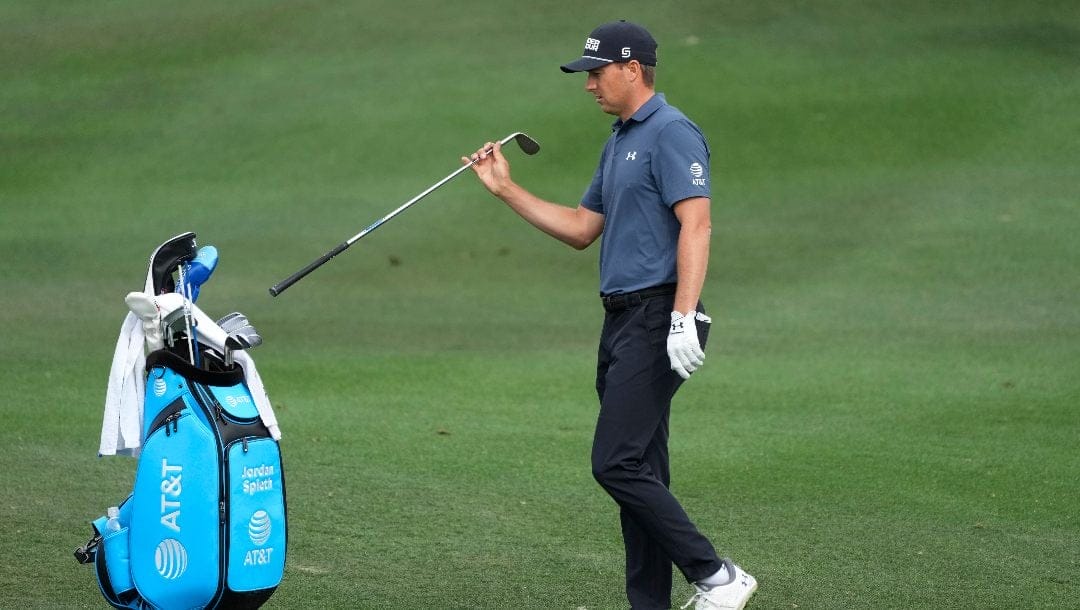 Jordan Spieth puts a club back in his bag after hitting his approach shot.