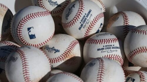 In this Feb. 14, 2020, file photo, baseballs sit in a bucket after they were used for fielding practice during spring training baseball workouts for pitchers and catchers at Cleveland Indians camp in Avondale, Ariz.