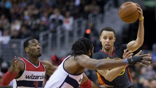 Stephen Curry with the Golden State Warriors attempts to get around John Wall during a game against the Washington Wizards on February 24, 2015.
