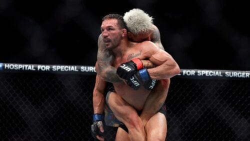 Michael Chandler with Brazil's Charles Oliveira on his back in a UFC 309 mixed martial arts lightweight title bout.